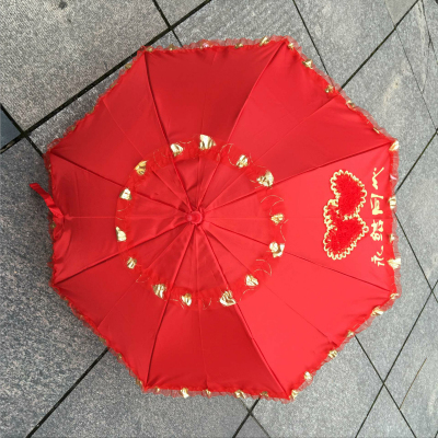 The bride's umbrella is a big red umbrella with a long handle