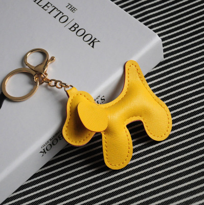 The new creative cross-grain leather dog model key ring with imitation wool ball hanging, leather puppy mobile phone pendant.